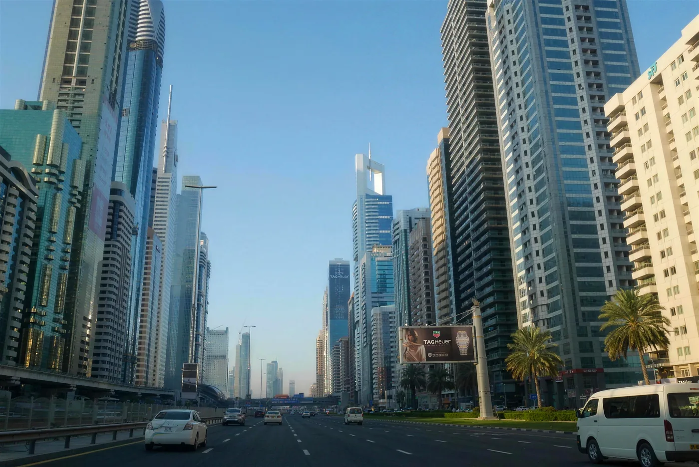 A Dubai fine on a rental car reaches you as a charge. A points fine from another emirate needs you to claim it first. Cars driving along Sheikh Zayed Road in Dubai between high-rise towers