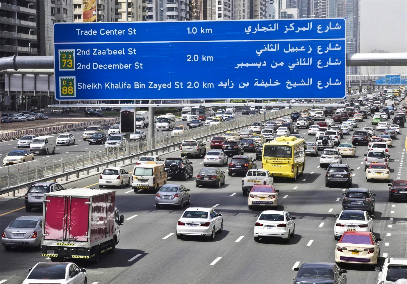 Every emirate issues points under the same federal schedule; what differs is the system behind them. Dense traffic under a blue Dubai road sign showing D73 Second Zaabeel Street and D88 Sheikh Khalifa Bin Zayed Street
